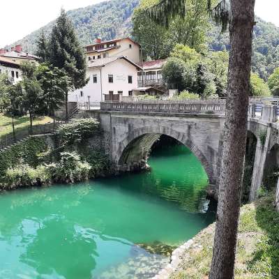 Eine Brücke über einen Fluss mit einem Gebäude im Hintergrund