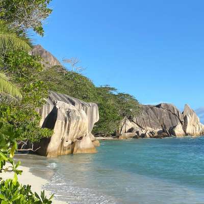 Ein Strand mit einem großen Felsen in der Mitte