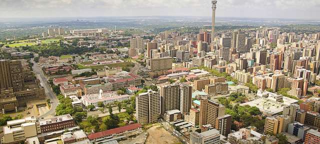 Blick auf Johannesburg Eine Stadt mit vielen Gebäuden und einem Turm im Hintergrund