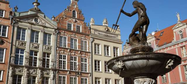 Ein Brunnen vor einem Gebäude mit einer Statue darauf