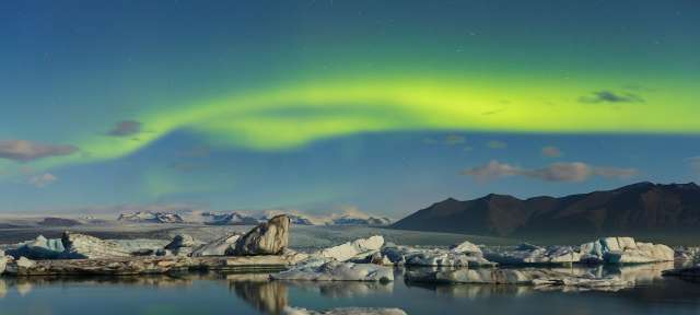 Nordlichter über dem Gletschersee Jökulsárlón Das Nordlicht scheint über einem See mit Eisbergen im Hintergrund