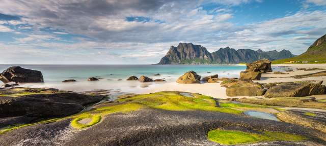 Ein felsiger Strand mit Bergen im Hintergrund