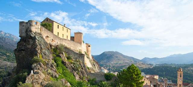 Corte: Blick vom Belvedere auf die Festung Ein Gebäude steht auf einem Felsen mit Blick auf eine Stadt