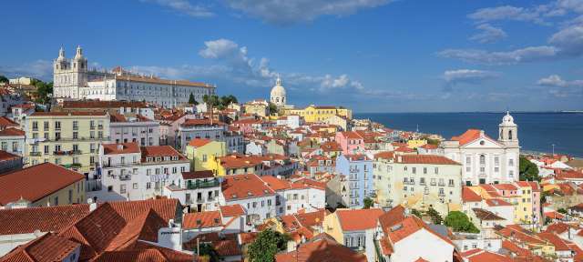 Lissabons ältestes Viertel: Alfama – ©Shutterstock Eine Stadt mit vielen bunten Gebäuden und roten Dächern
