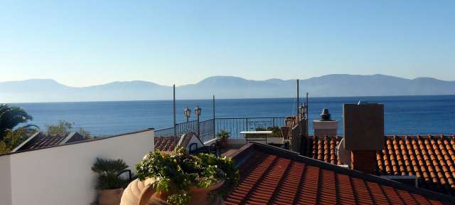 Ein Balkon mit Blick auf das Meer und die Berge