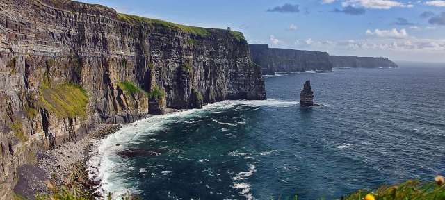 Cliffs of Moher Eine Klippe über dem Ozean mit einem großen Felsen darauf