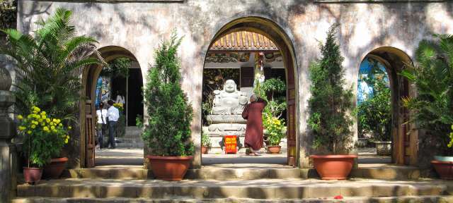 Reisefoto von: – ©Gabriele Wixforth, Umfulana Ein Mann steht vor einem buddhistischen Tempel