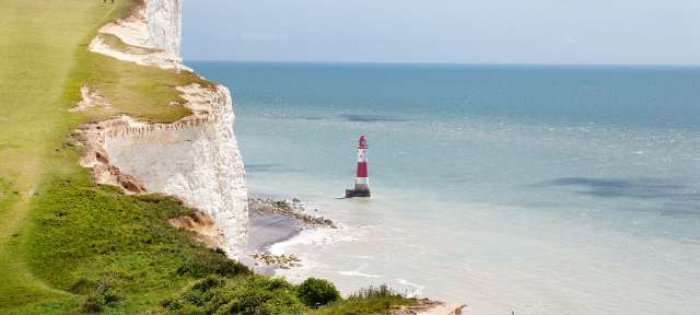 Beachy Head in East Sussex Ein rot-weißer Leuchtturm steht in der Mitte des Ozeans