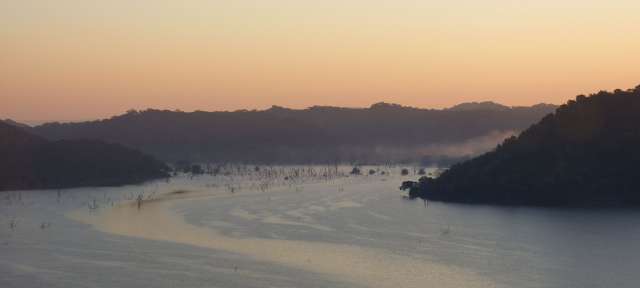 Stausee im Malilangwe Wildlife Reserve – ©Umfulana Ein Fluss mit Bergen im Hintergrund bei Sonnenuntergang