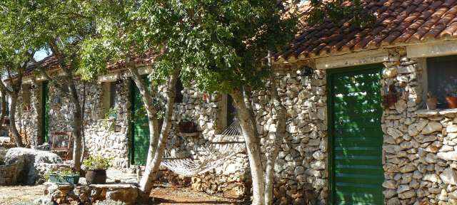 Cottage bei Krka Wasserfällen – ©Umfulana Eine Gruppe von Steinhäusern mit grünen Türen