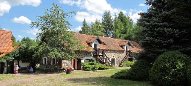 Gut am Laschmiedensee – ©Martin Bach Eine Gruppe von Menschen steht vor einem Steingebäude
