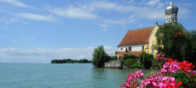 Eine Kirche steht auf einem kleinen Hügel über einem See