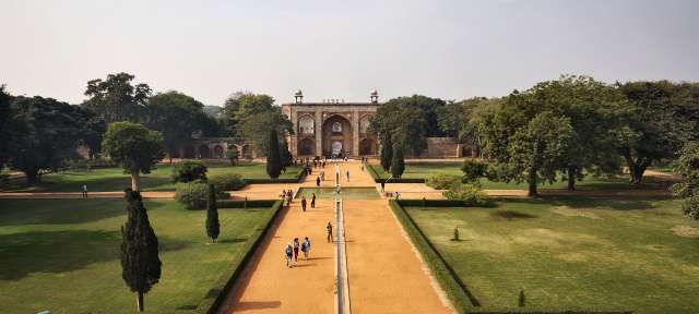 Humayun Mausoleum Eine Gruppe von Menschen geht durch einen Park in Richtung eines großen Gebäudes