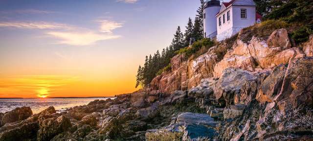 Ein Leuchtturm steht auf einem felsigen Hügel über dem Ozean
