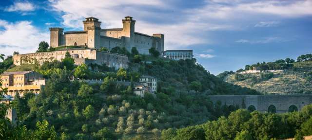 Burgen und Berge, Wälder und Felder: Albornoz in Umbrien Ein großes Schloss sitzt auf einem Hügel mit Bäumen umgeben