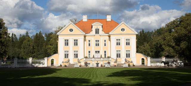 Gutshaus Palmse, Reisefoto von – ©Barbara Harbecke, Umfulana Ein großes gelbes und weißes Gebäude mit einem roten Dach