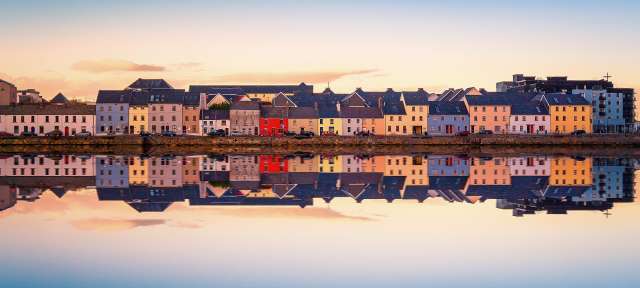 Galway Eine Reihe von bunten Häusern spiegelt sich im Wasser