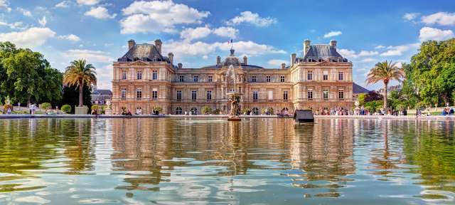 Jardin du Luxembourg Ein großes Gebäude spiegelt sich in einem Teich