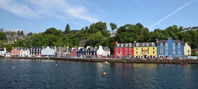Tobermory – Mull Eine Reihe von bunten Gebäuden an einem Fluss