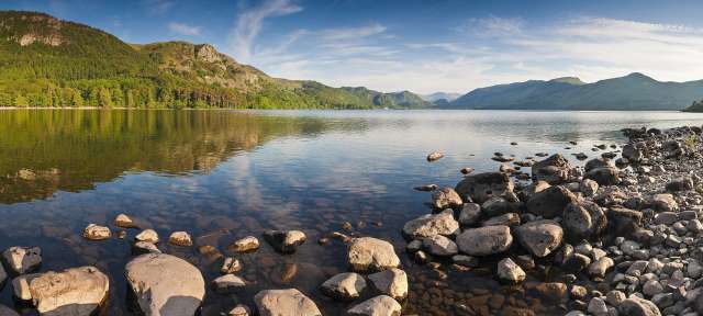 Lake District Ein See mit Bergen im Hintergrund und Felsen am Ufer