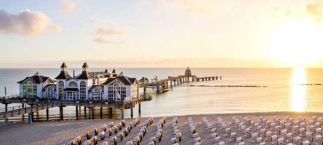 Ein Strand mit vielen Strandkörben und einem Gebäude im Hintergrund
