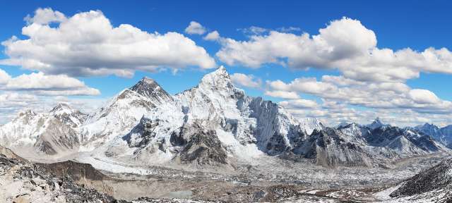 Ein schneebedeckter Berg mit einem blauen Himmel im Hintergrund