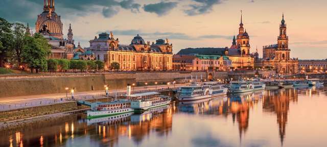 Dresden am Elbufer Ein Fluss mit vielen Booten und Gebäuden im Hintergrund