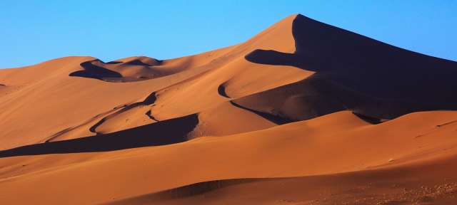 Fotoparadies: Sossusvlei Eine große Sanddüne mit einem blauen Himmel dahinter