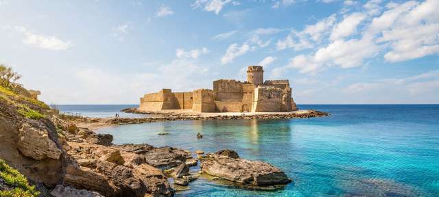 Ein großes Schloss sitzt auf einer kleinen Insel im Ozean
