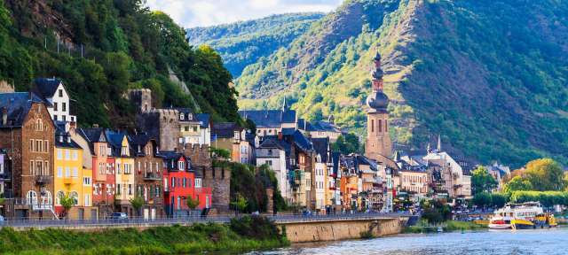 Romantische Radtour: Mosel bei Cochem Ein Boot fährt auf einem Fluss in der Nähe einer Stadt