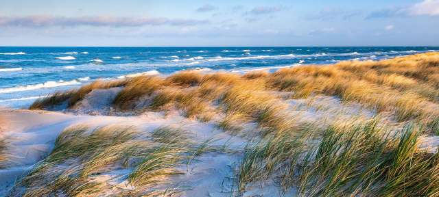 Eine Sanddüne führt zum Ozean