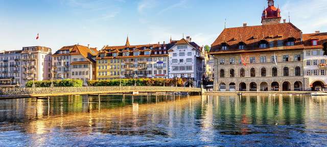 Luzern, Schweiz Eine Brücke über einen Fluss mit Gebäuden im Hintergrund