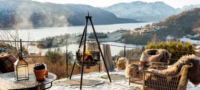 Ein Tisch und Stühle im Schnee mit einem Feuer im Hintergrund