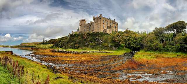 Stammsitz eines schottischen Clans: Dunvegan Castle Ein großes Schloss sitzt auf einem Hügel über einem Fluss