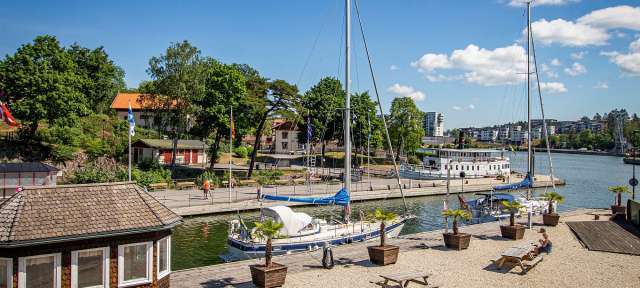 „Trollywood“: Trollhättan Ein kleines Boot liegt an einem Dock neben einem Picknicktisch