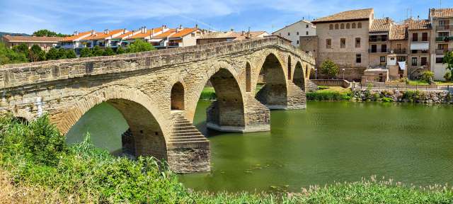 Eine Brücke über einen Fluss mit Gebäuden im Hintergrund