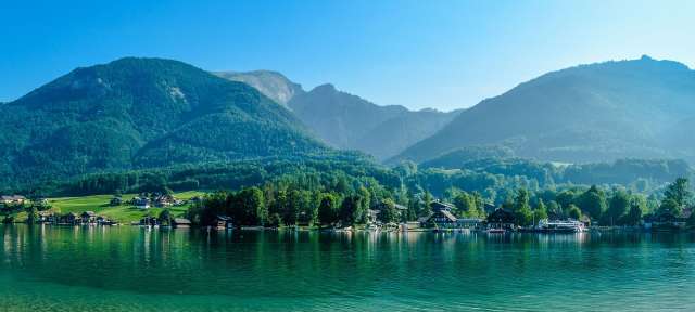 Ein See mit Bäumen und Bergen im Hintergrund
