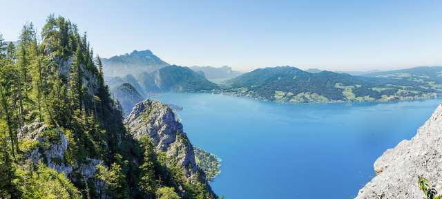 Fantastischer Blick über den Attersee Ein Mann steht auf einem Felsen mit Blick auf einen See