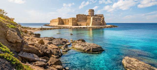 Ein großes Schloss sitzt auf einer kleinen Insel im Ozean