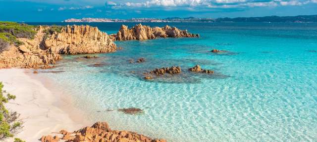Rosafarbener Sandstrand: Sardinien Ein Strand mit weißem Sand und blauem Wasser