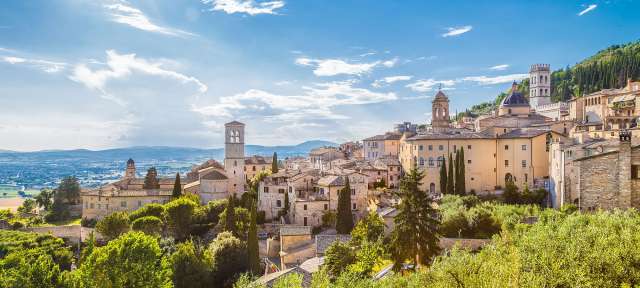 Das grüne Herz Italiens: Umbrien Die Sonne scheint durch die Wolken über einem kleinen Dorf