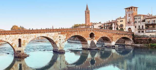 Eine Brücke über einen Fluss mit einem Turm im Hintergrund