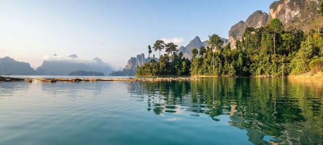 Surat Thani: Khao Sok Nationalpark Ein See mit Bäumen und Bergen im Hintergrund