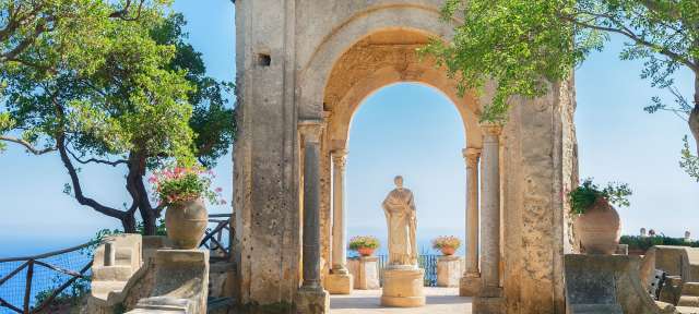 Ravello im Sommer: Amalfi Küste Eine Statue steht unter einem Steinbogen mit Blick auf den Ozean