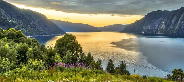 Ein großer See umgeben von Bergen und Bäumen