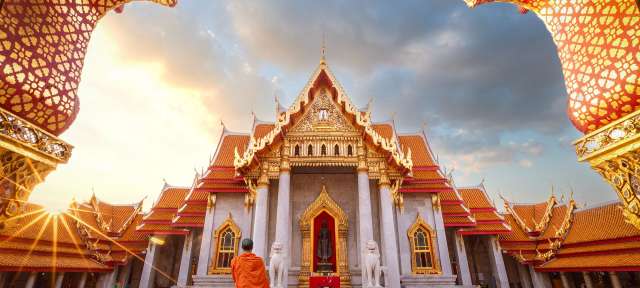 Bangkok: weißer Marmortempel Ein Mönch geht vor einem großen Tempel spazieren