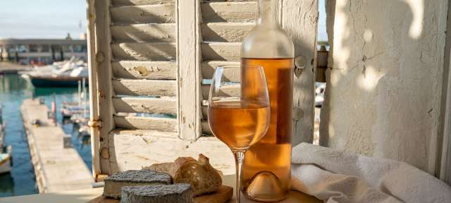 Eine Flasche und ein Glas Wein stehen auf einem Tisch