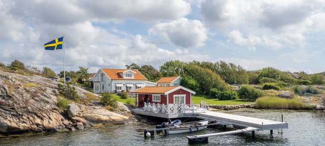 Haus an der schwedischen Westküste Ein rot-weißes Haus mit einer schwedischen Flagge davor