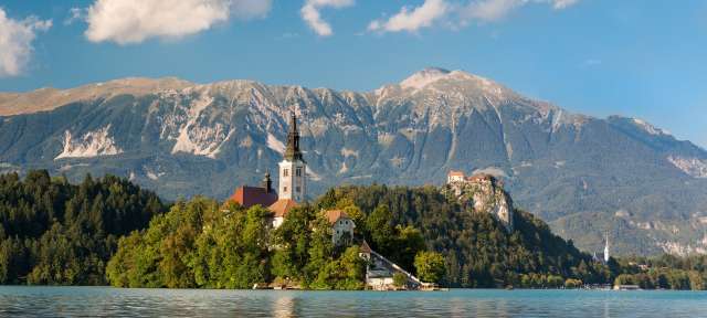 Eine Kirche auf einer kleinen Insel im See mit Bergen im Hintergrund
