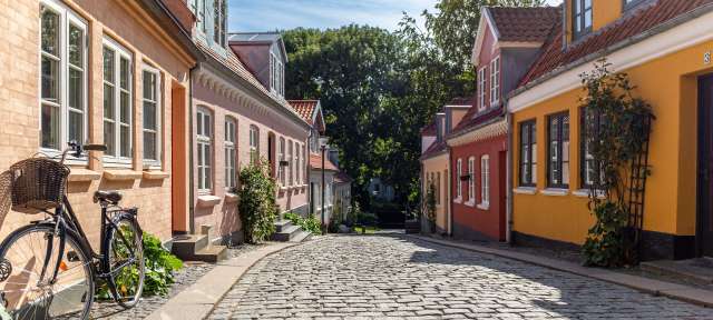 Geburtsort von Hans Christian Andersen: Odense Ein Fahrrad mit Korb sitzt auf einer gepflasterten Straße